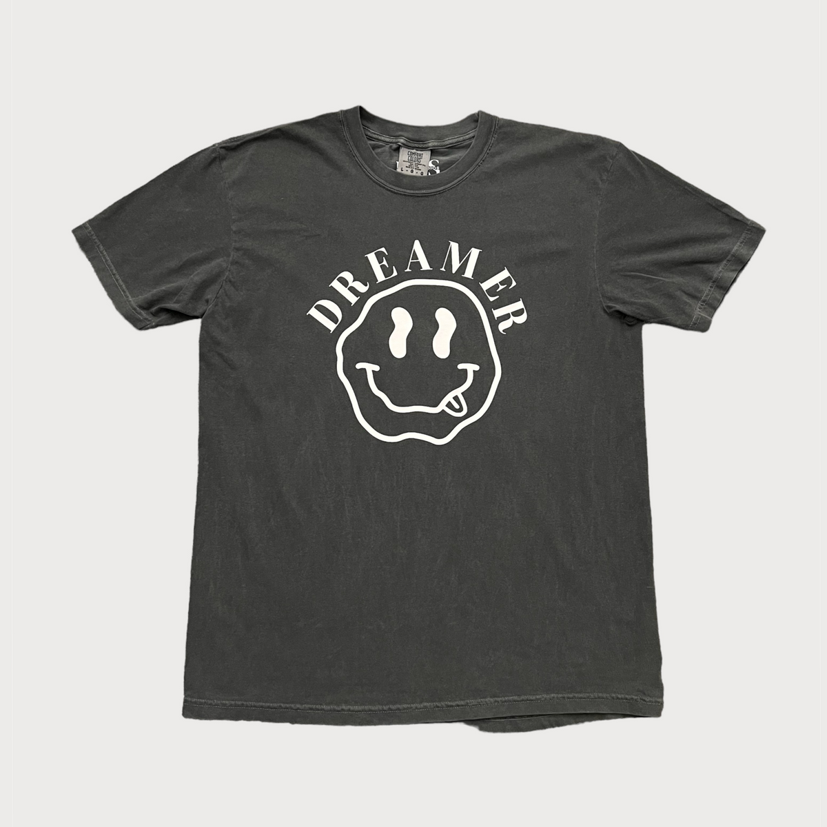 A gray t-shirt with the text 'DREAMER' and a graphic smiley face on the front.