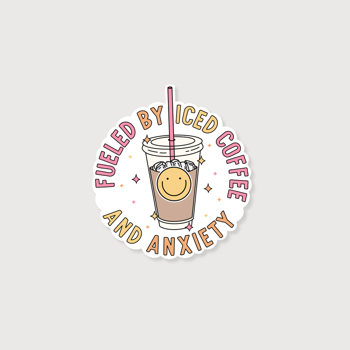 A circular die-cut sticker featuring a cartoon iced coffee cup with a smiling face and the text 'FUELED BY ICED COFFEE AND ANXIETY' in pink and tan lettering, shown on a light gray background.
