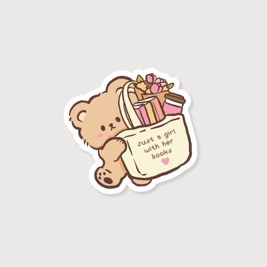 A die-cut sticker featuring a cute cartoon teddy bear holding a book bag filled with books and flowers. The book bag has the text 'just a girl with her books' and a small pink heart, shown on a light gray background.