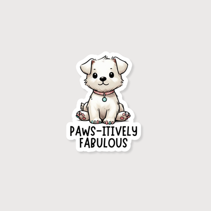 A die-cut sticker featuring a cute cartoon white puppy sitting above the text 'PAWS-ITIVELY FABULOUS' in black lettering, shown on a light gray background.