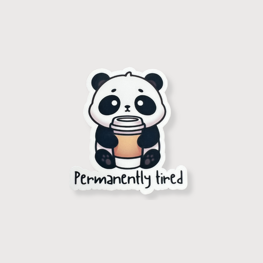 Sticker of a panda holding a coffee cup with 'Permanently tired' text on a light gray background