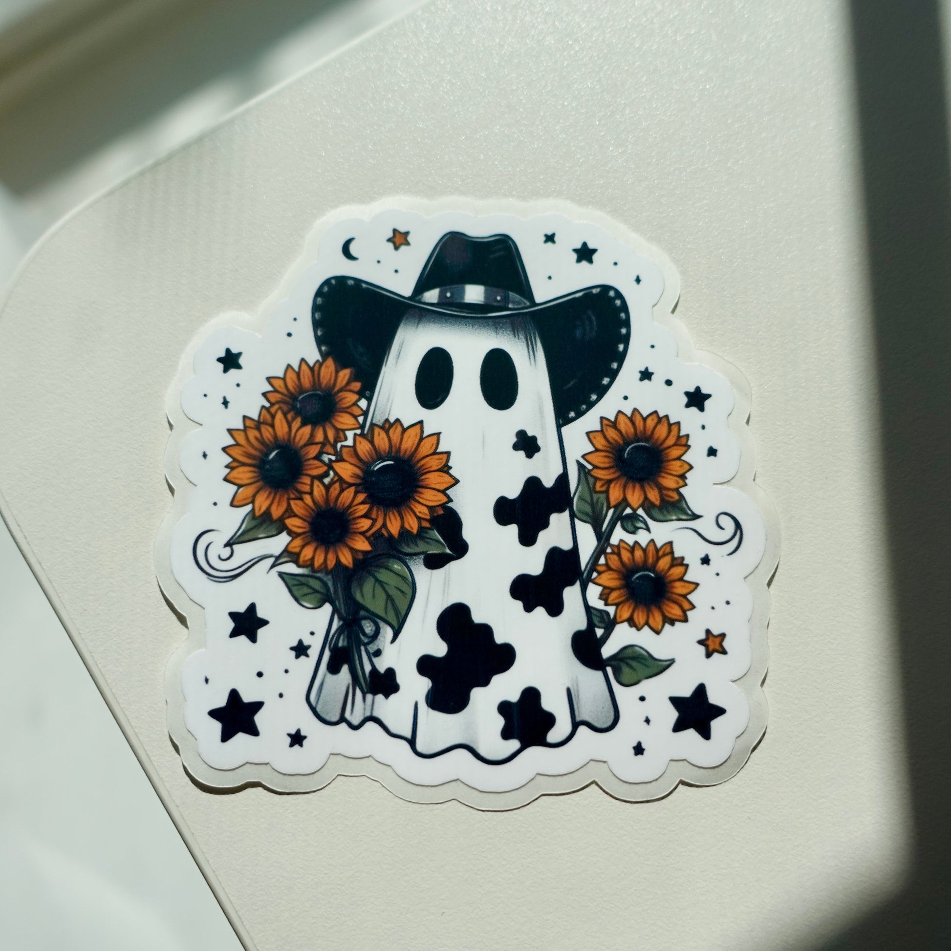 Black cow print ghost with cowboy hat holding sunflowers